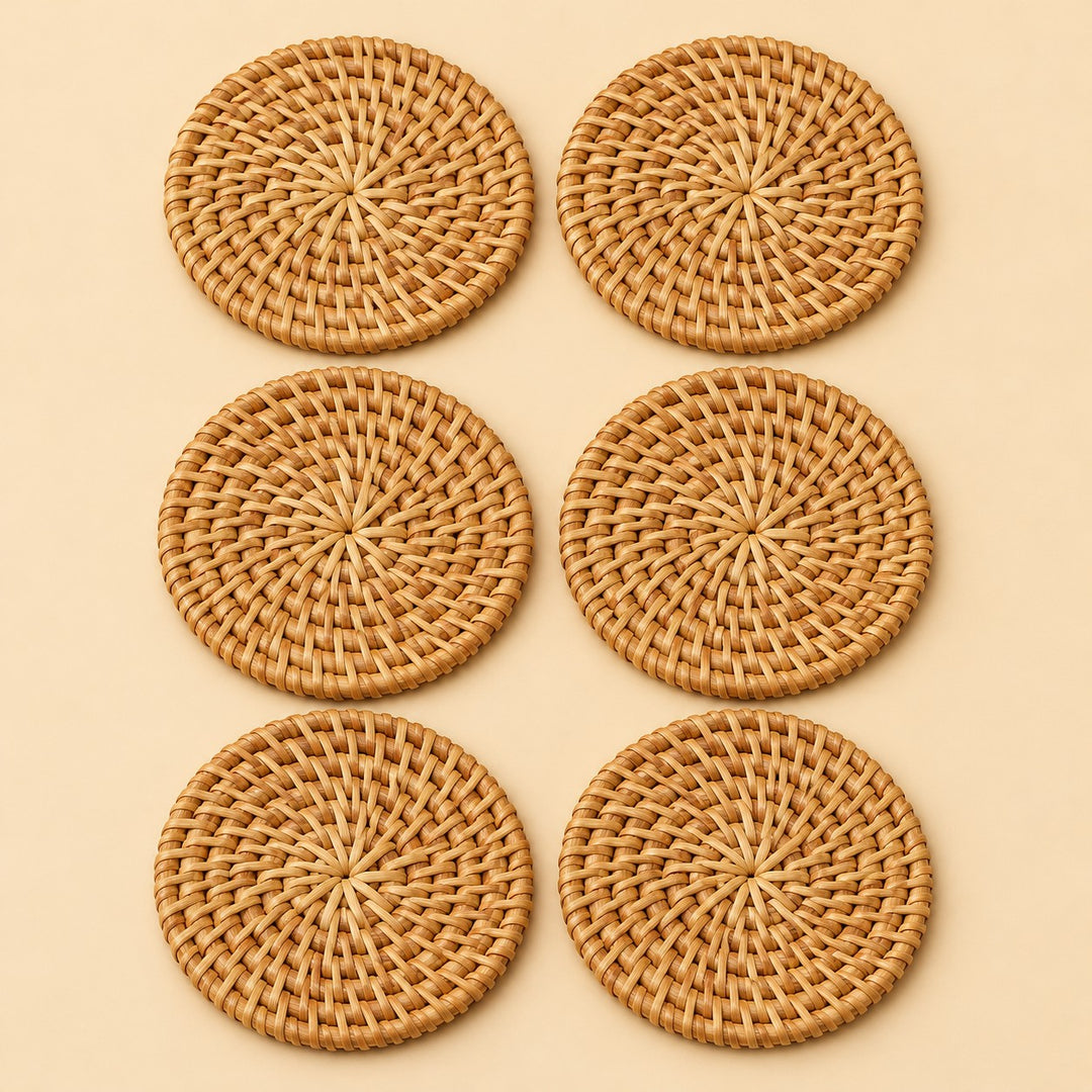 Set of six round rattan coasters arranged together on a soft beige studio background.
