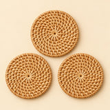 Set of three round rattan coasters shown together on a soft beige studio background.