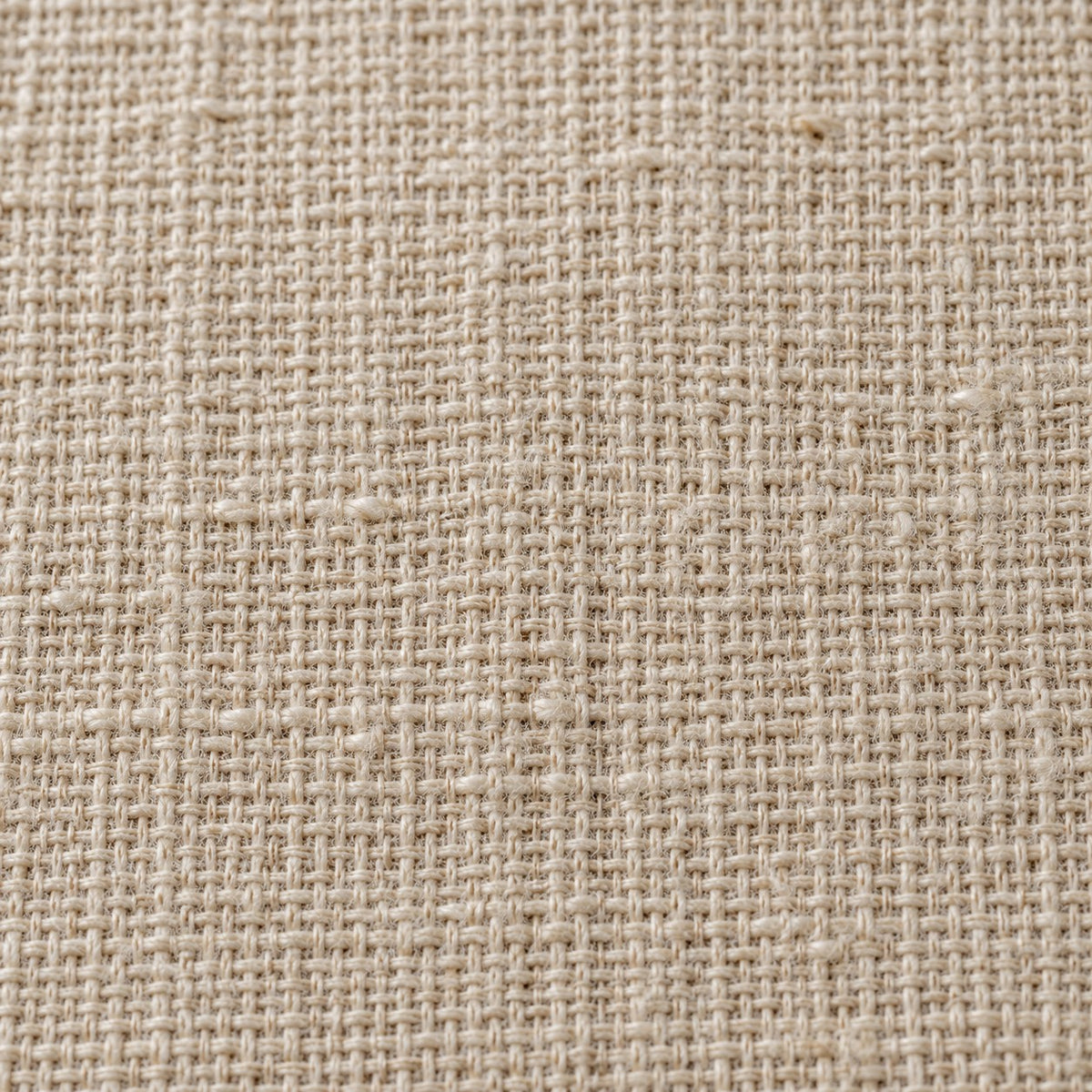 Close view of the beige table runner's fine crosshatch cotton linen weave and matte finish.