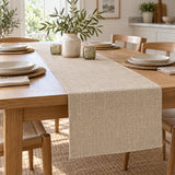 Beige linen table runner creates a tidy centerpiece zone on a light wood dining table.