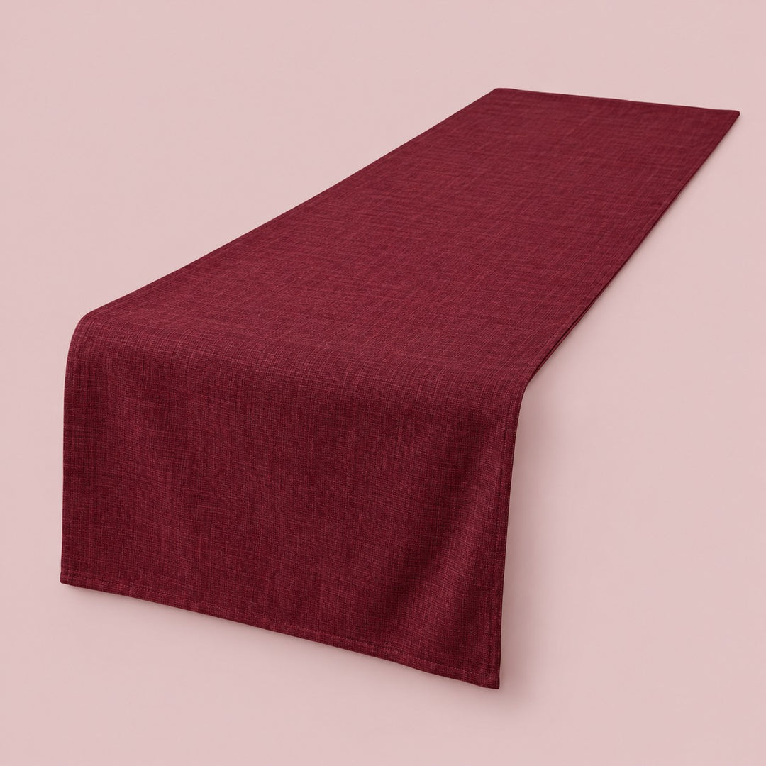 Burgundy rectangular cotton linen table runner centered on a soft blush studio background.