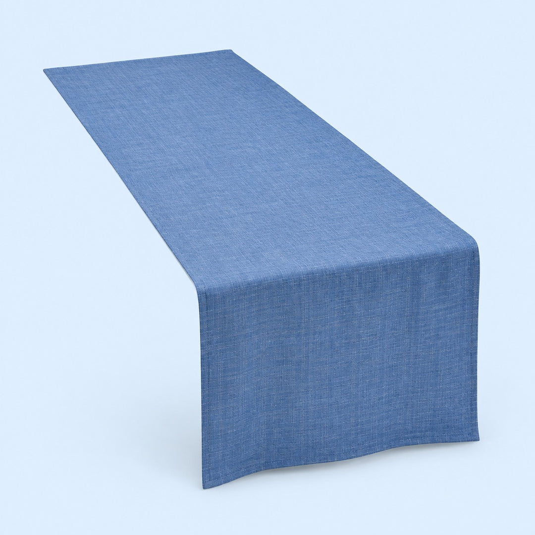 Blue rectangular cotton linen table runner centered on a soft blue studio background.