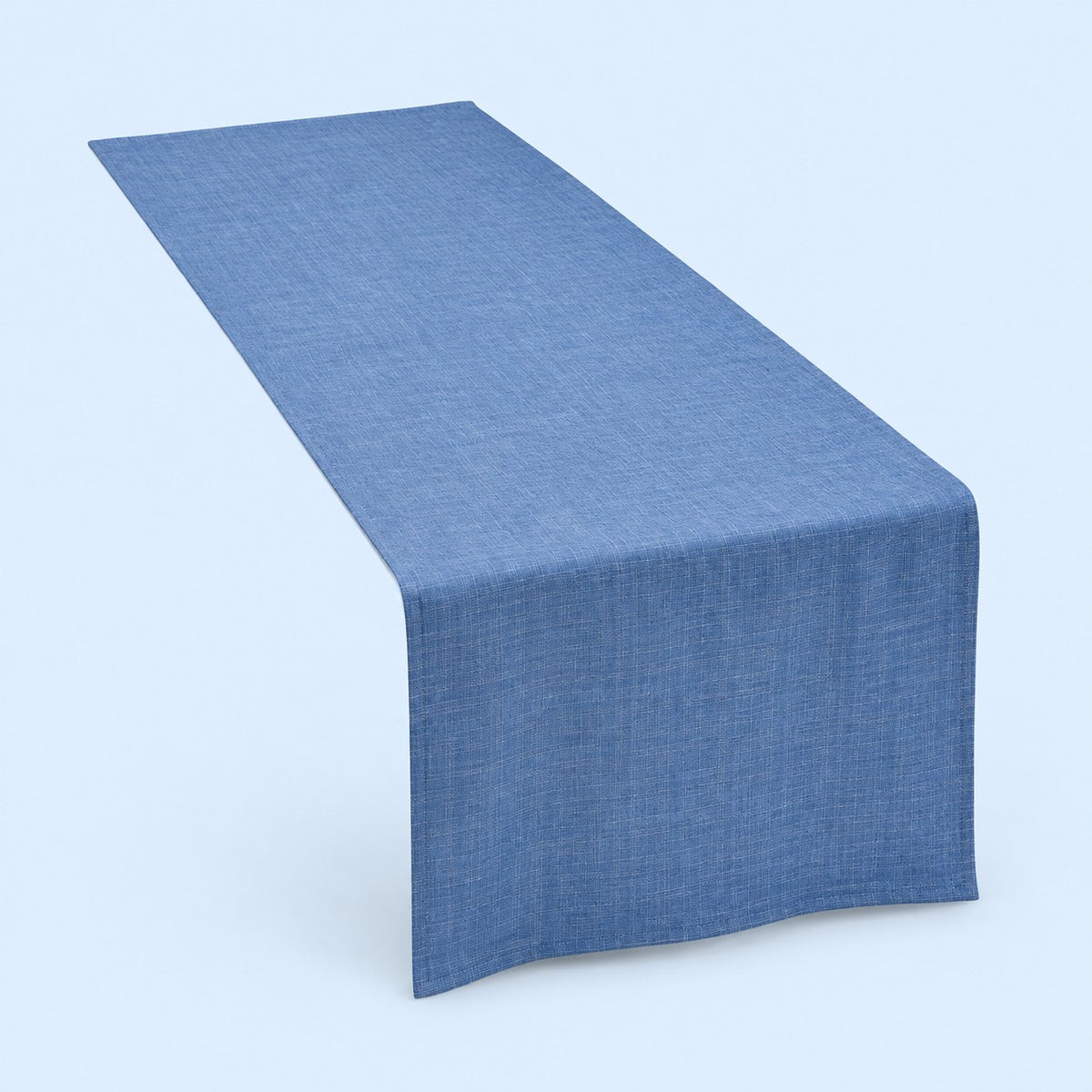 Blue rectangular cotton linen table runner centered on a soft blue studio background.