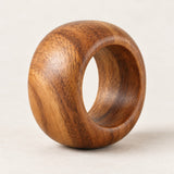 A single acacia wood napkin ring shows its smooth rounded shape and warm natural grain.