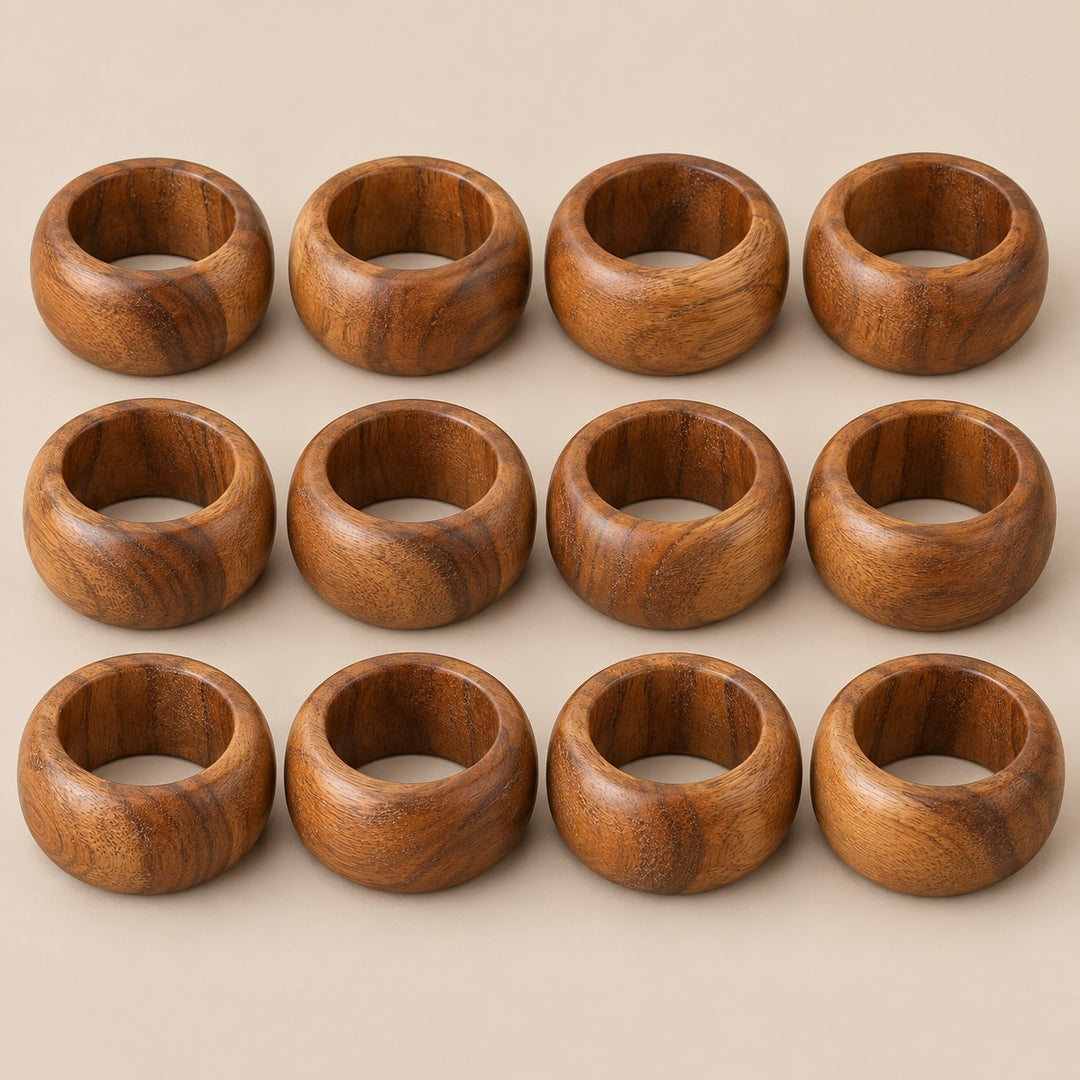 Set of 12 acacia wood napkin rings shown together against a light warm taupe background.