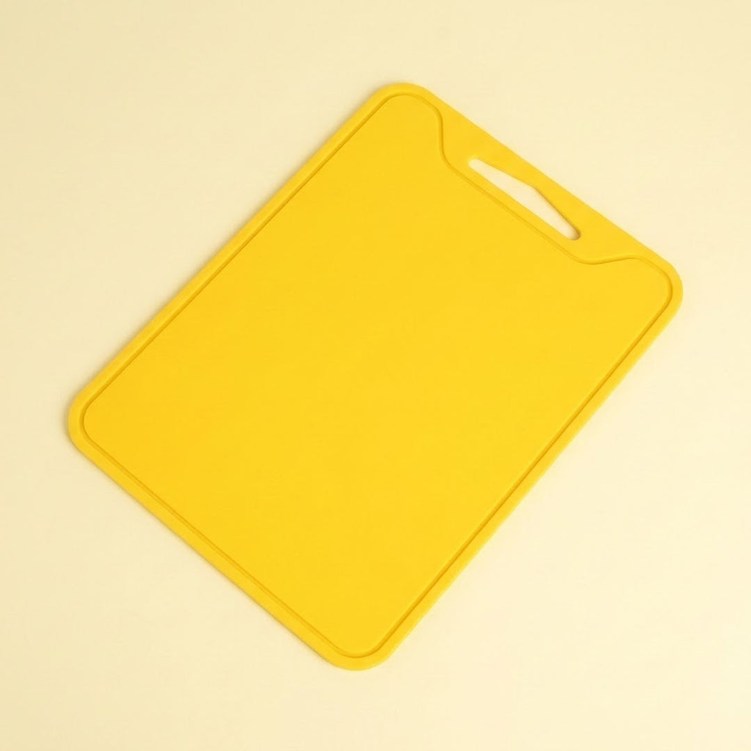A bright yellow rectangular cutting board with rounded corners and a handle cutout in the top right, shown on a light cream background.