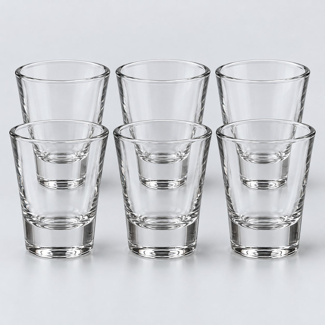 Six tapered clear glass shot glasses form the Tapered style set against a pale backdrop.