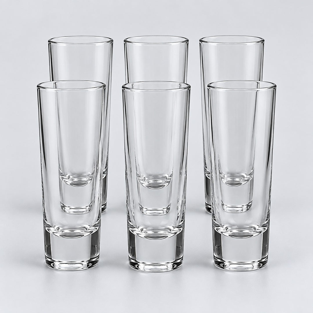 Six tall cylindrical clear glass shot glasses show the Tall Cylinder style on a pale backdrop.