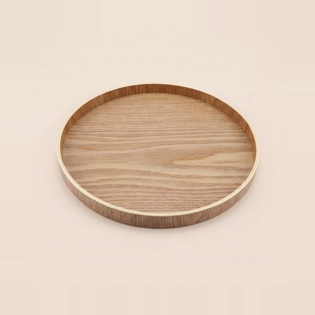 A round wooden tray with a smooth, light-colored wood-grain top and a contrasting darker brown rim, shown on a solid, warm off-white background.