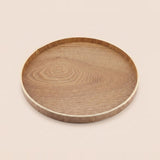 A round wooden serving tray with a natural oak grain pattern and a light-colored rim, shown on a solid beige background.