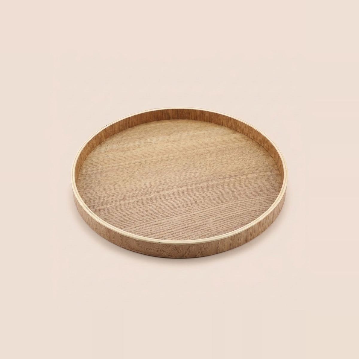A round wooden serving tray with a natural light oak finish and visible wood grain, shown from a top-down perspective on a solid, warm off-white background.