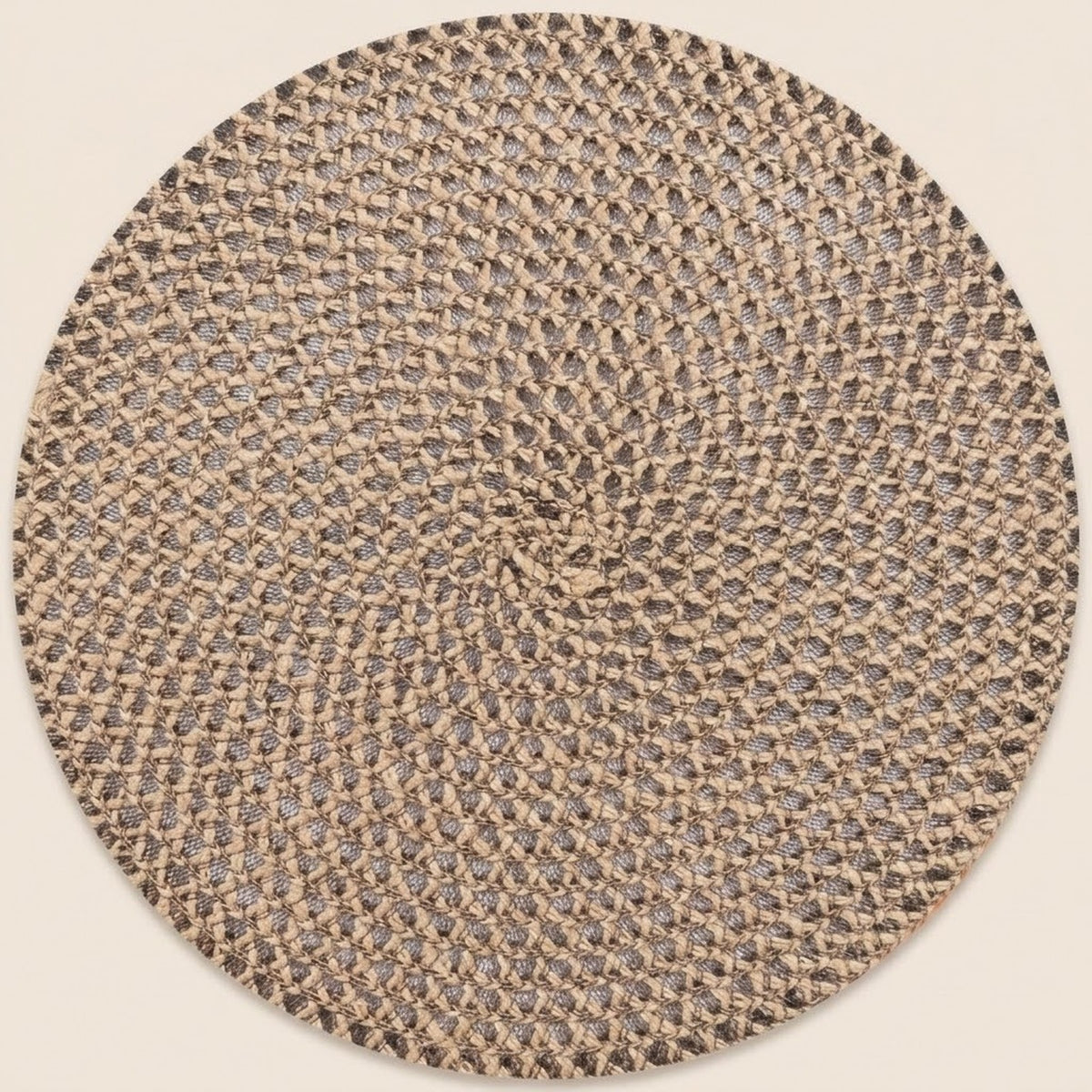 A round braided rug with a textured woven pattern in beige, brown, and gray tones, shown against a solid light beige background.
