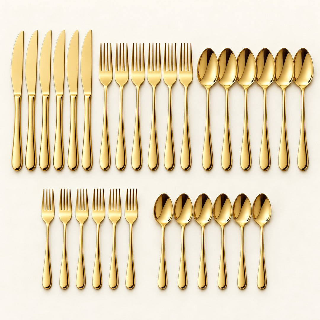 The 30-piece gold stainless steel cutlery set is grouped on a pale ivory studio backdrop.