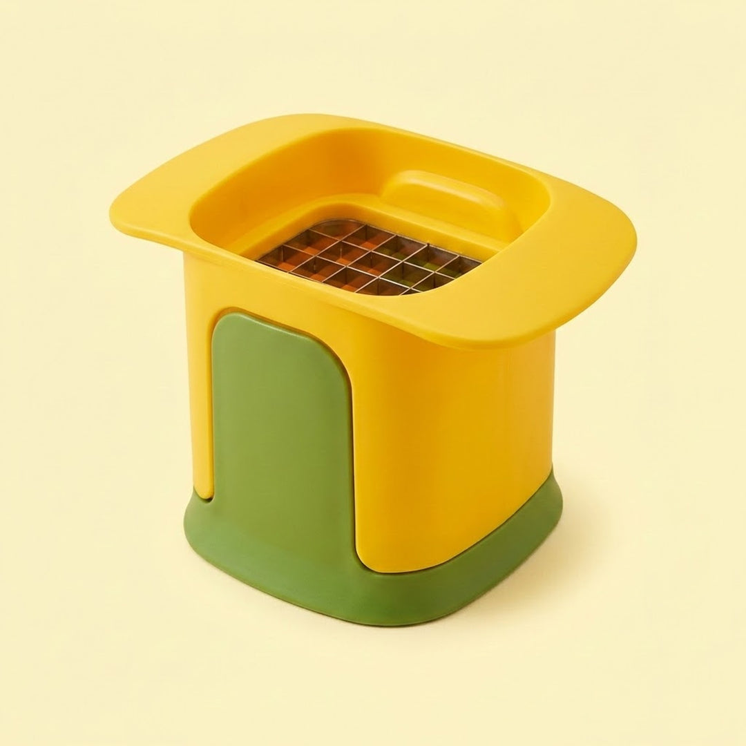 A small kitchen accessory with a bright yellow body, a green front panel, and a dark grid-like insert at the top, photographed on a plain warm cream background.