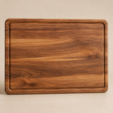 The large rectangular wood cutting board is centered on a pale tan studio background.
