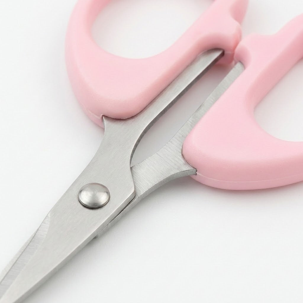 Pink plastic-handled scissors with silver metal blades, shown close up on a white background.
