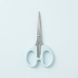 A pair of scissors with light blue handles and silver stainless steel blades, centered on a pale blue background.