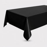 A black rectangular tablecloth draped over a table, shown against a plain light gray studio background.