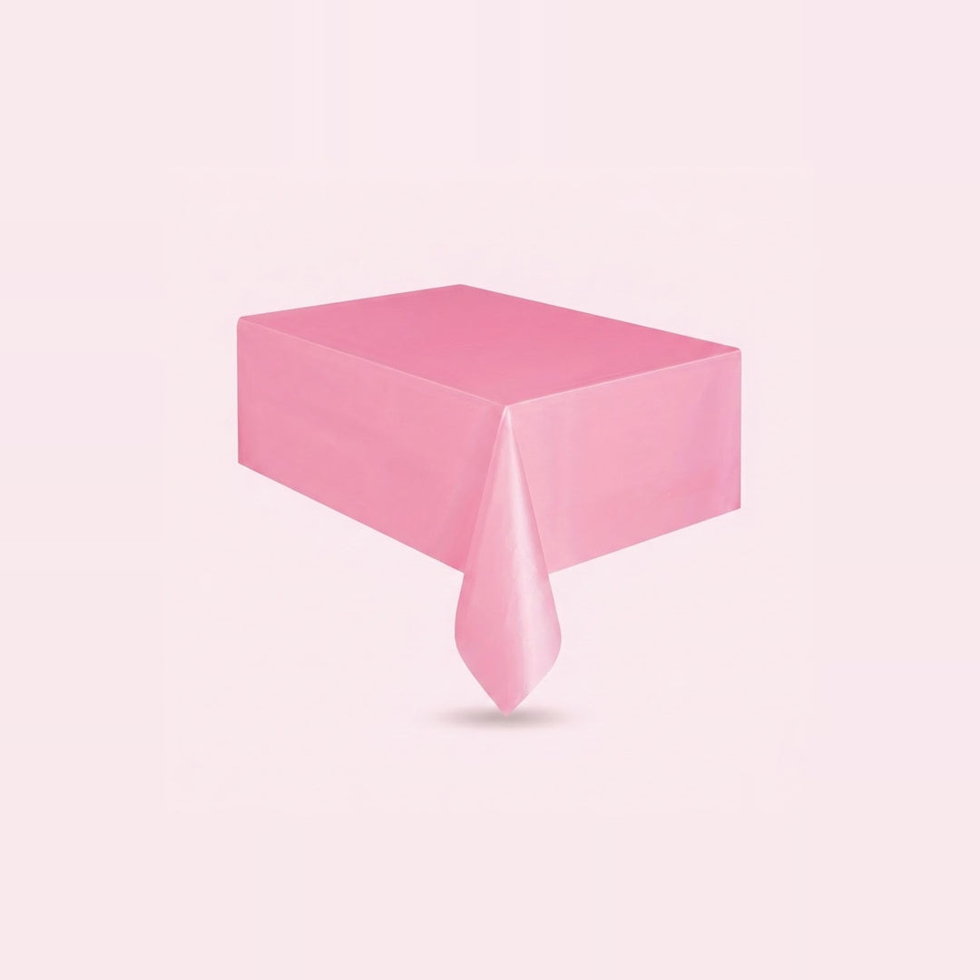 A pink rectangular tablecloth draped over a table, shown against a solid pale pink background.