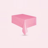 A pink rectangular tablecloth draped over a table, shown against a solid pale pink background.