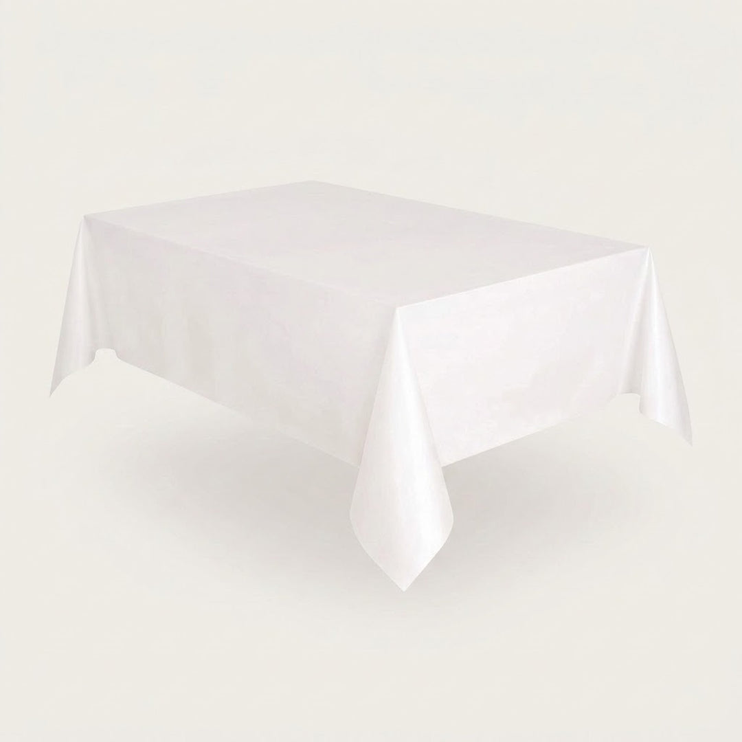 A plain white rectangular tablecloth draped over a table, shown against a light warm gray studio background.