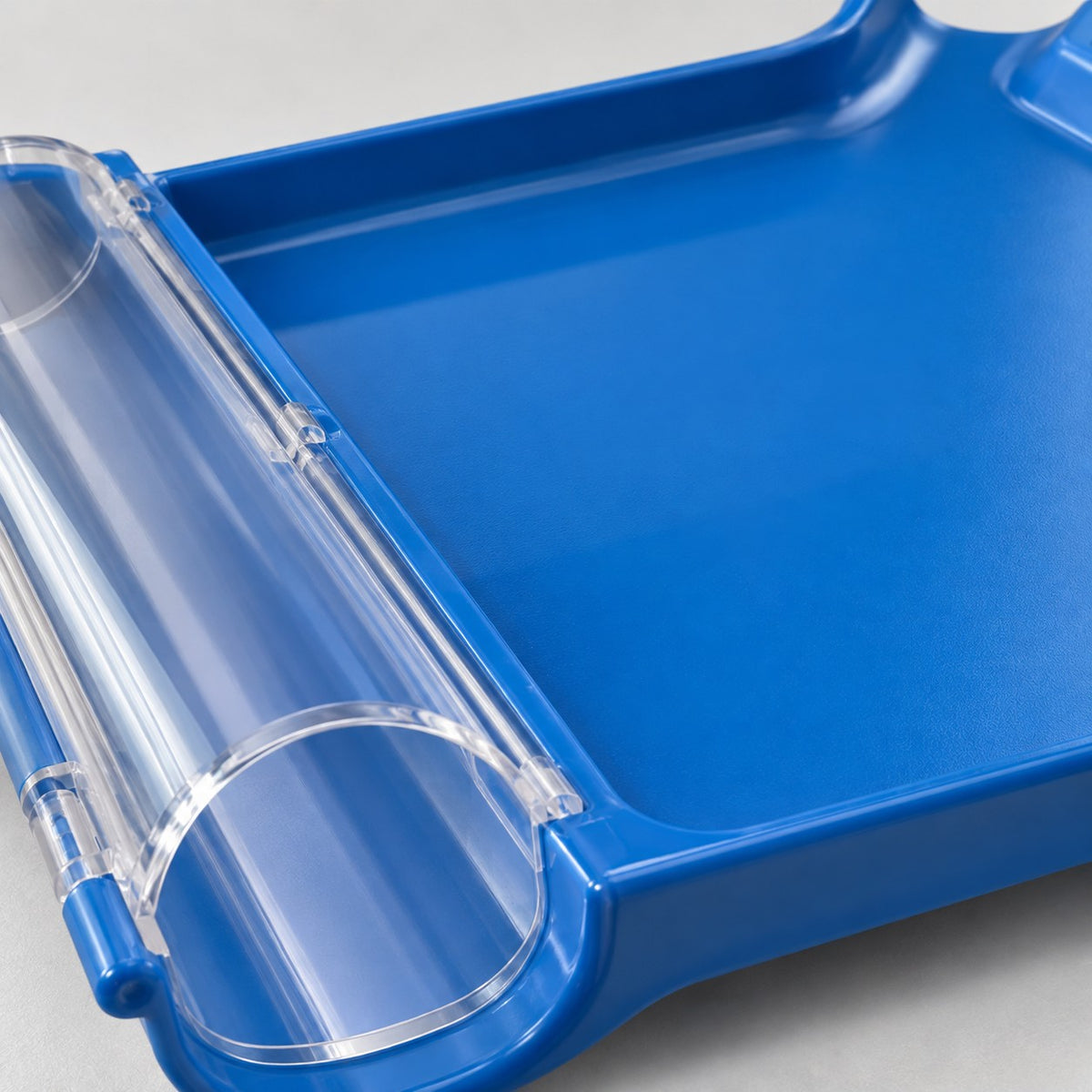 Macro detail of the blue pill counting tray's glossy plastic surface, raised rim, and clear collector hinge.