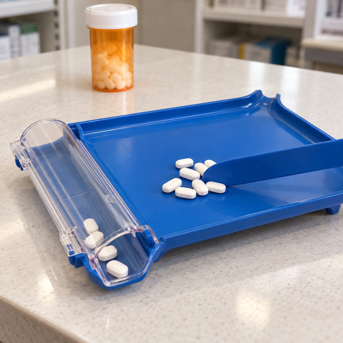 Blue pill counting tray and spatula guide tablets toward the clear collector on a pharmacy counter.