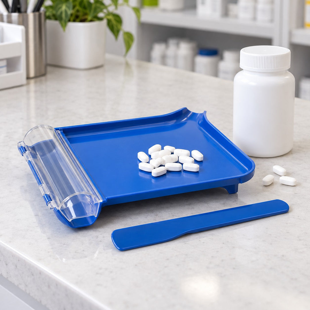 Compact blue pill counting tray and spatula shown beside a stock bottle and a few tablets for scale.