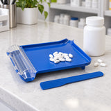 Compact blue pill counting tray and spatula shown beside a stock bottle and a few tablets for scale.