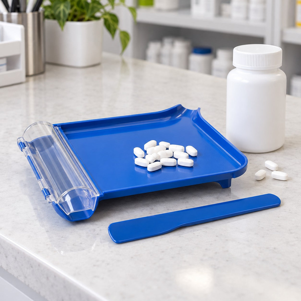 Compact blue pill counting tray and spatula shown beside a stock bottle and a few tablets for scale.