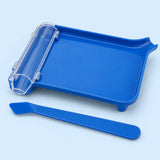 Blue plastic pill counting tray with clear chute and matching spatula on a pale blue studio background.
