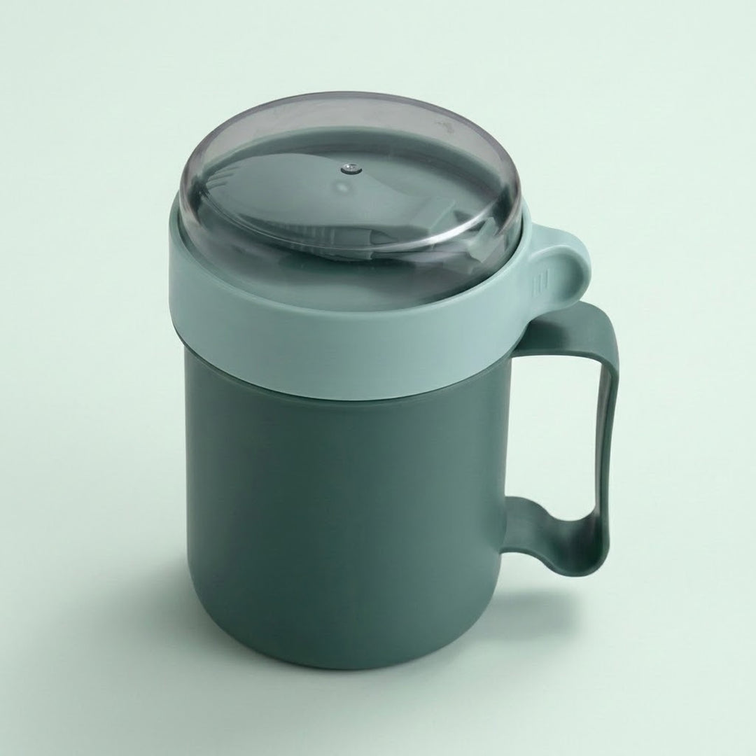 A dark green insulated mug with a matching dark green handle and a translucent dark gray lid, shown on a light green background.