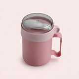A pink silicone mug with a matching pink handle and a clear plastic lid, shown on a solid pale pink background.