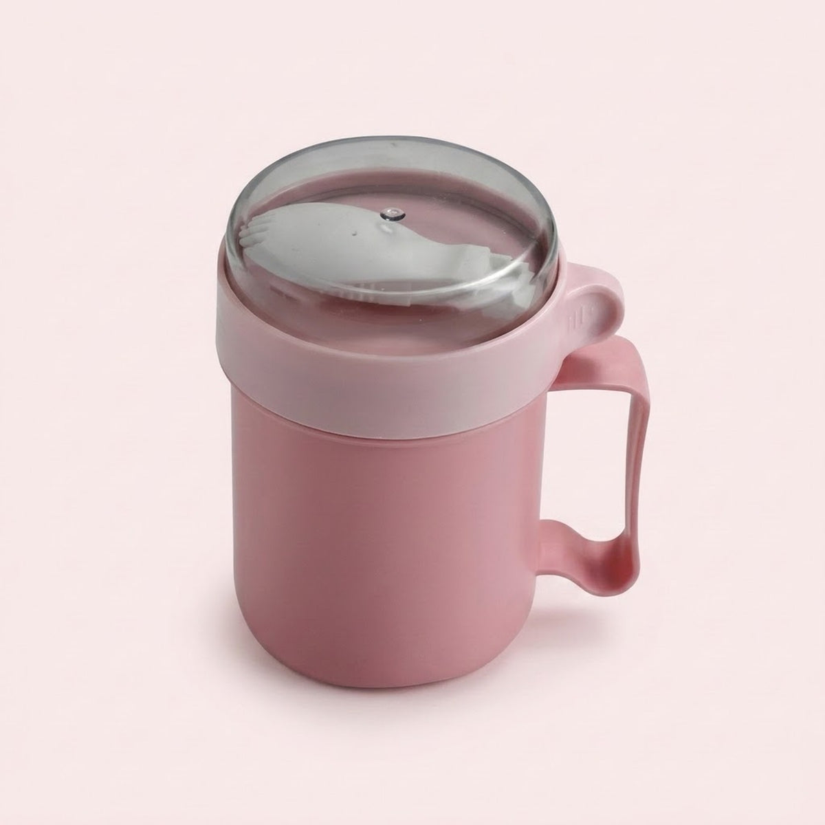 A pink silicone mug with a matching pink handle and a clear plastic lid, shown on a solid pale pink background.