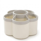 A flower-shaped silicone cup organizer with five compartments, featuring a warm cream body and light gray rims, shown on a white background.