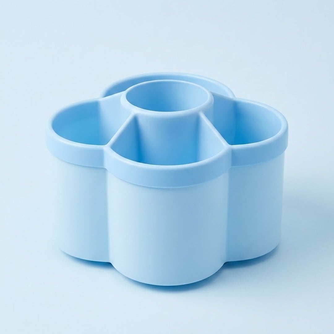 A light blue silicone or plastic multi-compartment organizer with a flower-like silhouette and a central round cup, shown on a matching light blue background.