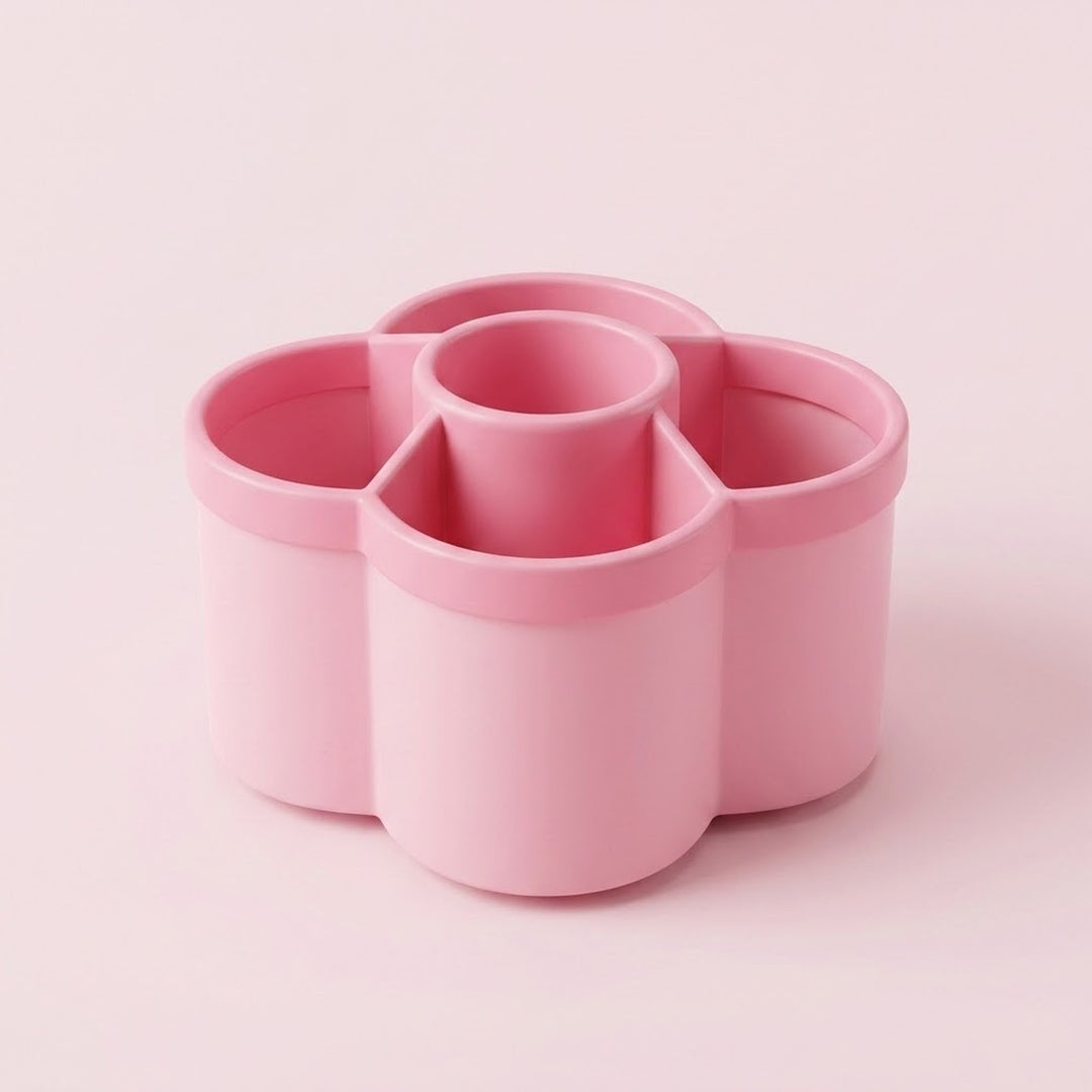 A pink flower-shaped multi-compartment cup organizer with four outer cups and one central cup, shown on a solid pale pink background.