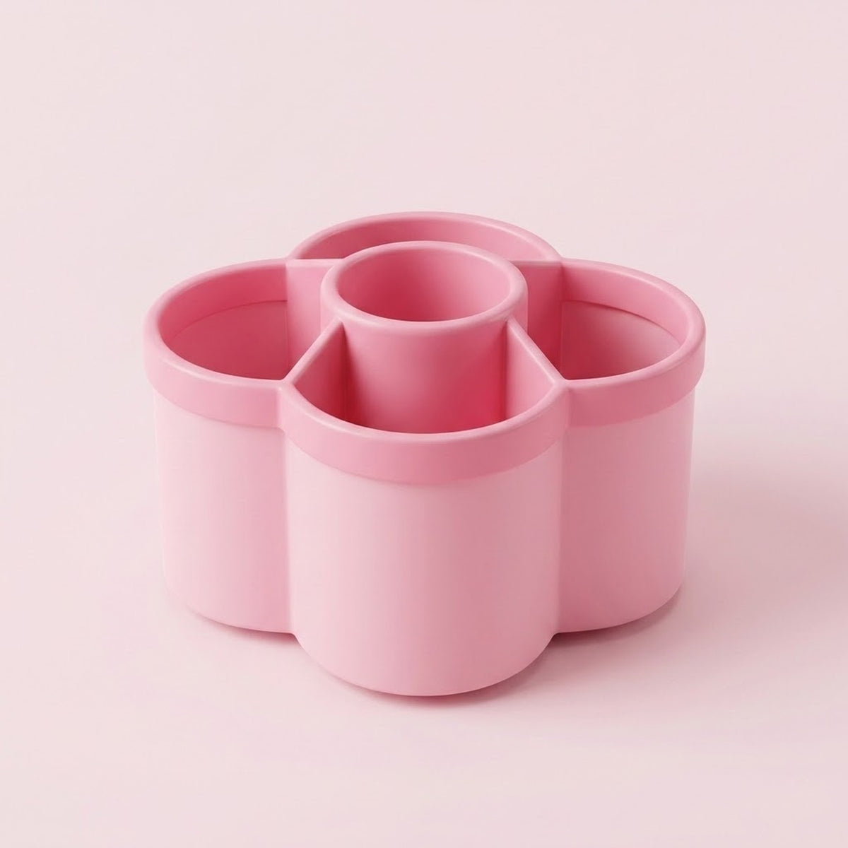A pink flower-shaped multi-compartment cup organizer with four outer cups and one central cup, shown on a solid pale pink background.