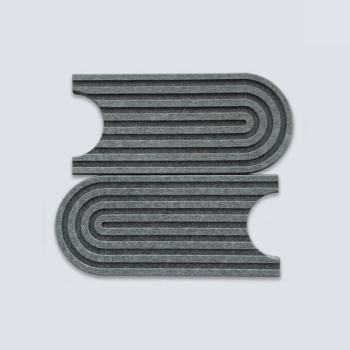 Two gray felt book-shaped mats with concentric curved stripes, displayed on a light gray background.