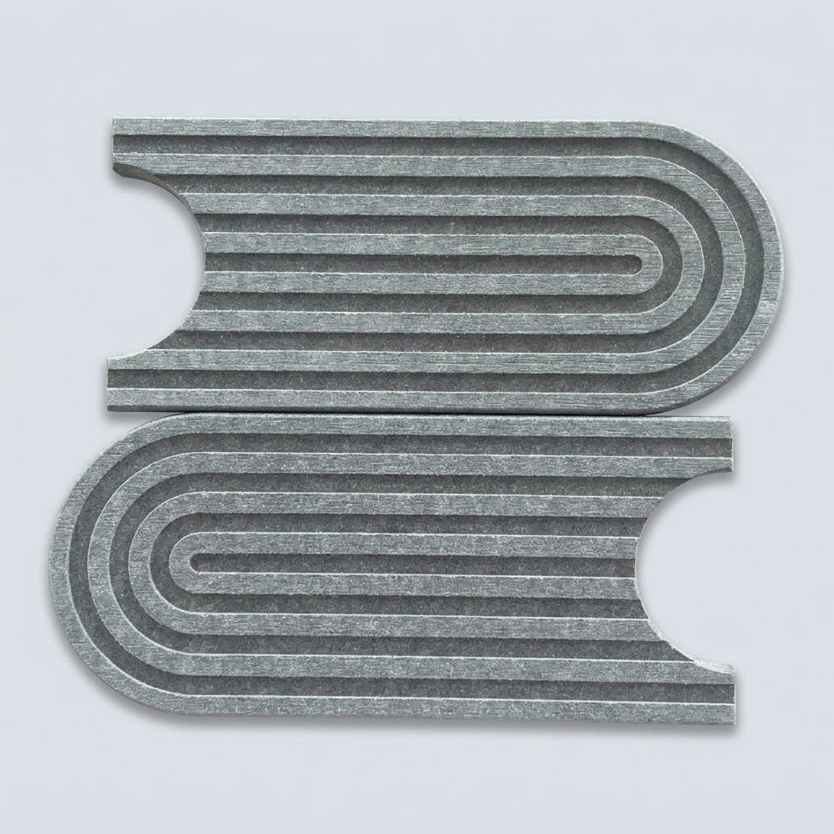 Two gray felt rectangular pieces with curved cutouts and concentric wavy ridges, shown on a light gray background.