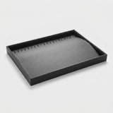 A black rectangular jewelry display tray with a curved, padded interior, photographed on a clean light gray background.