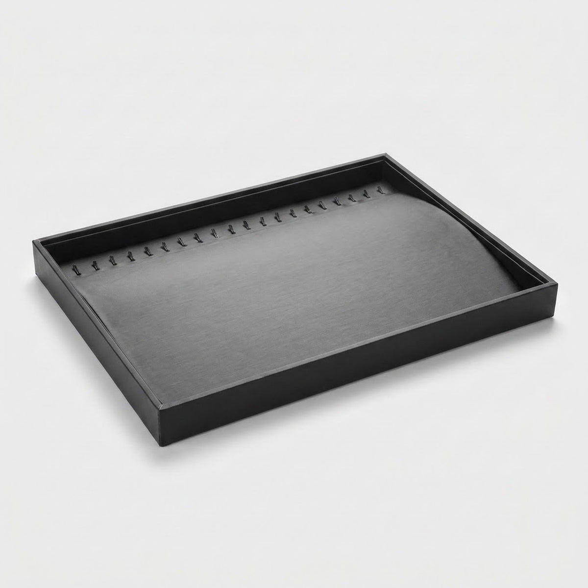A black rectangular jewelry display tray with a curved, padded interior, photographed on a clean light gray background.