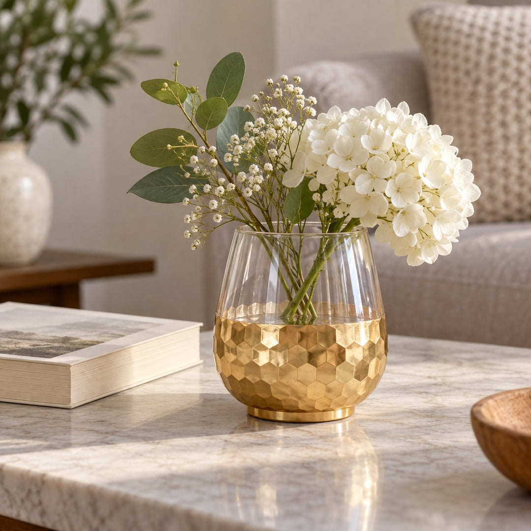 Small Gold Honeycomb Glass Vase sits beside a paperback and flowers to show its tabletop scale.