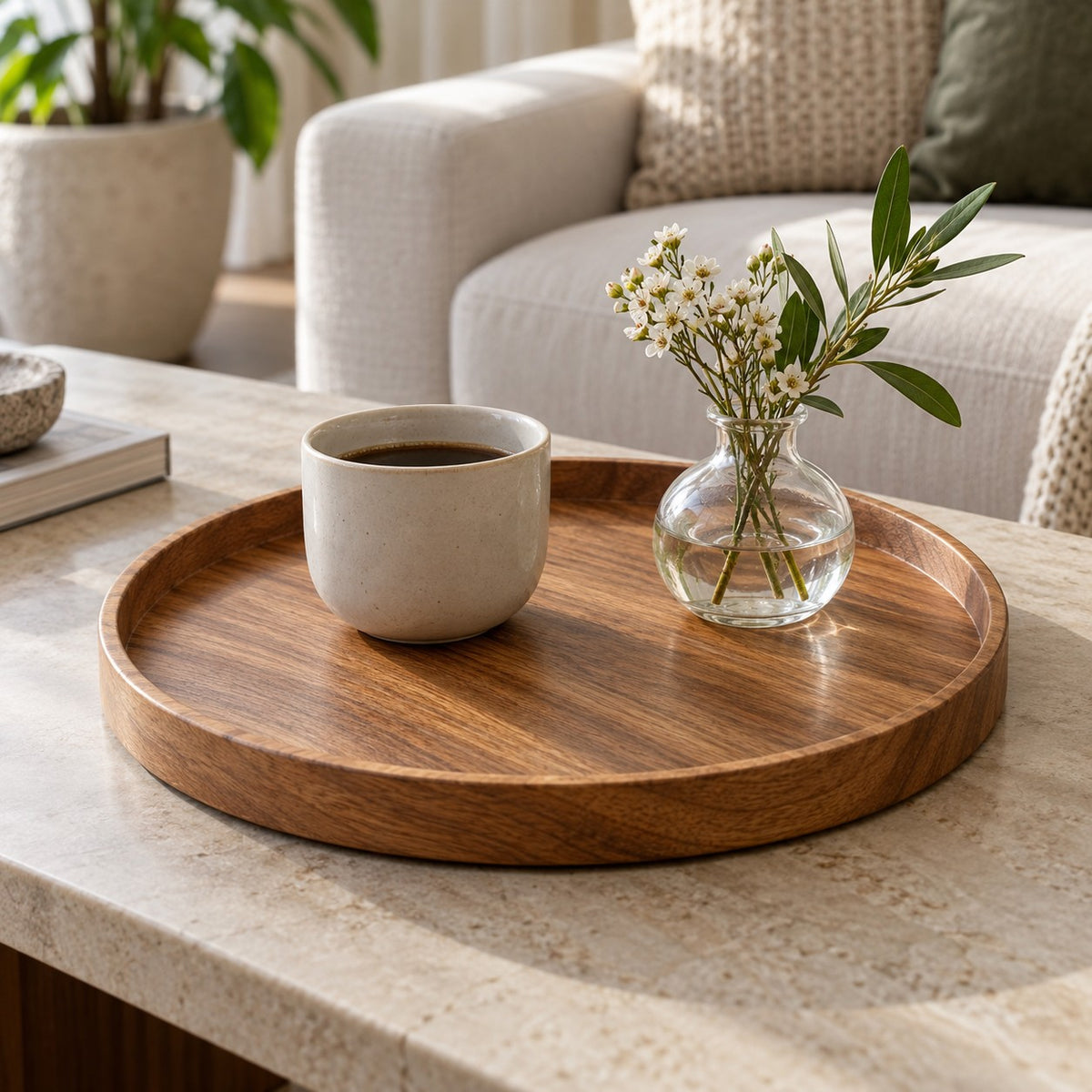 Round wooden serving tray gathers a cup and small vase neatly on a living room coffee table.