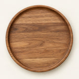 Small 20 cm round wooden serving tray centered on a light warm studio background.