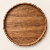 Medium 25 cm round wooden serving tray centered on a light warm studio background.