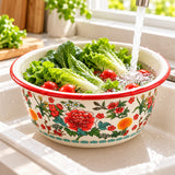 Red Floral enamel kitchen basin holds leafy vegetables for washing in a bright home kitchen.