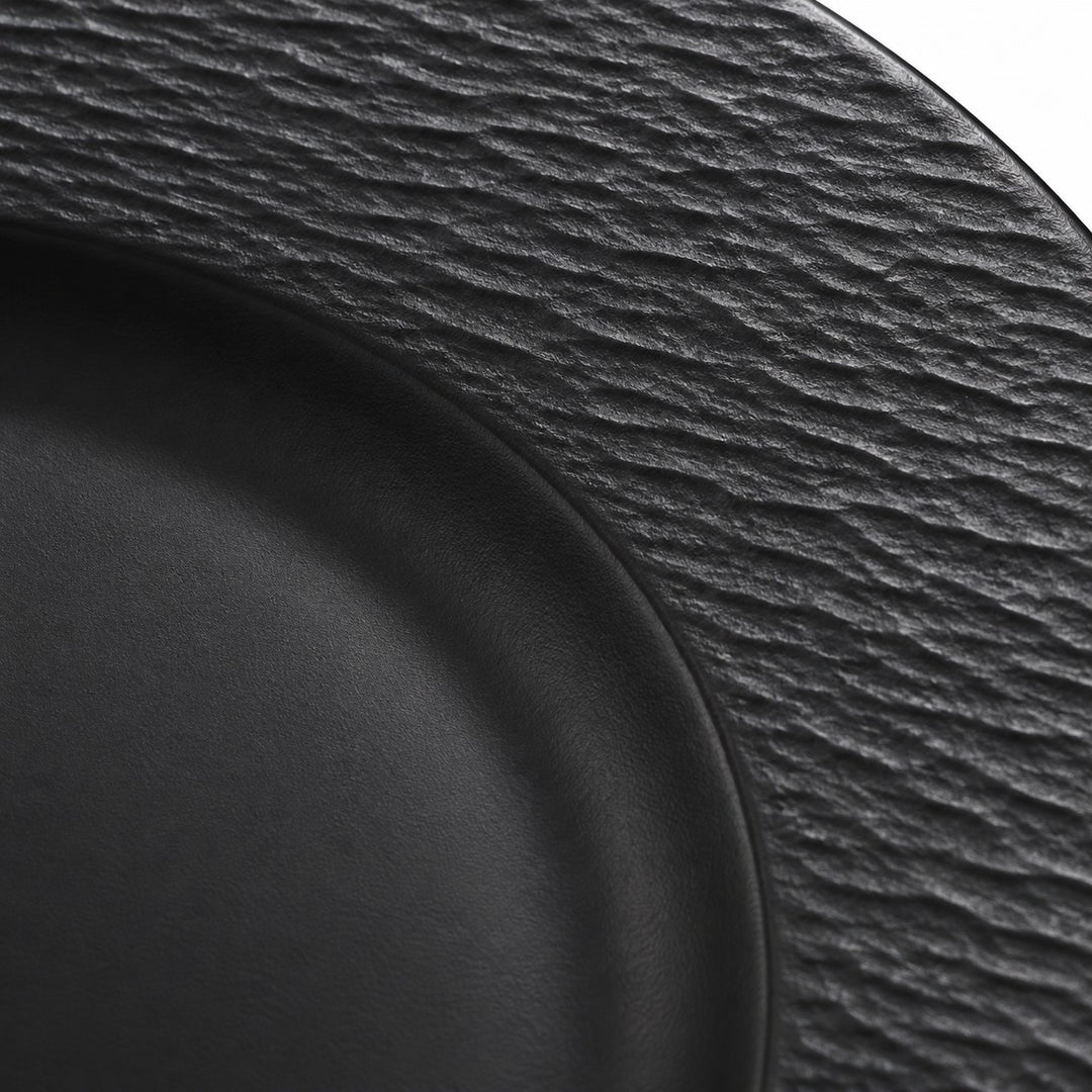 Macro detail shows the black melamine plate’s rippled texture beside its smooth center well.