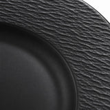 Macro detail shows the black melamine plate’s rippled texture beside its smooth center well.