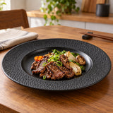 Black melamine serving plate presents Korean barbecue with meat and vegetables in its center well.